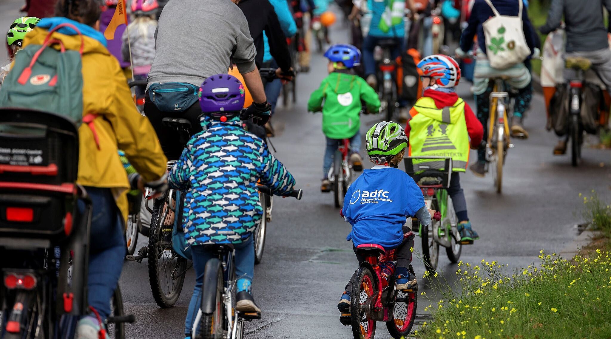Kinder und Erwachsene fahren gemeinsam auf einer Straße Fahrrad