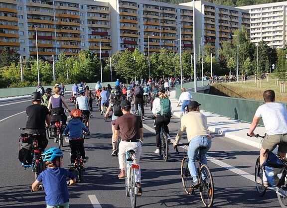 Gruppe von Radfahrenden fährt über eine breite Straße