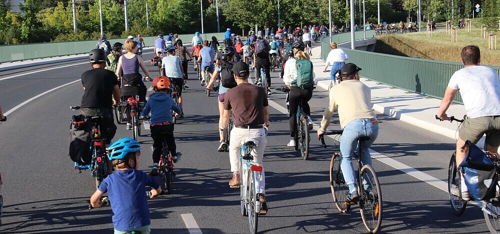 Gruppe von Radfahrenden fährt über eine breite Straße