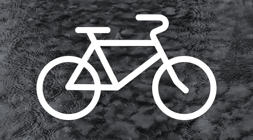 weißes Fahrrad vor einem grauen Hintergrund mit Wassertropfen