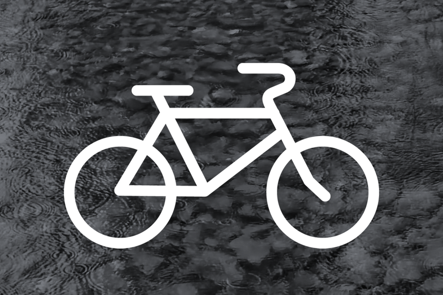 Geisterrad weißes Fahrrad vor einem grauen Hintergrund mit Wassertropfen