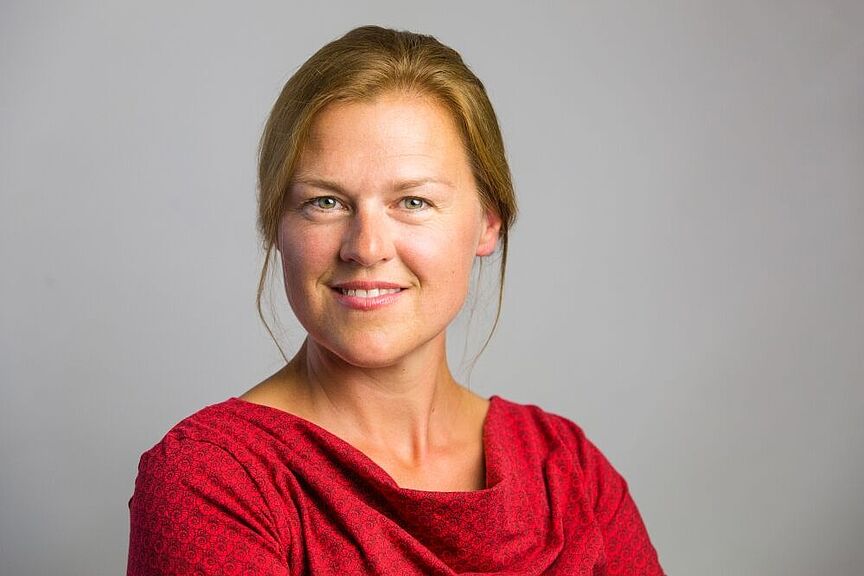 Barbara Körbs Porträtaufnahme von Barbara Körbs vor grauem Hintergrund.