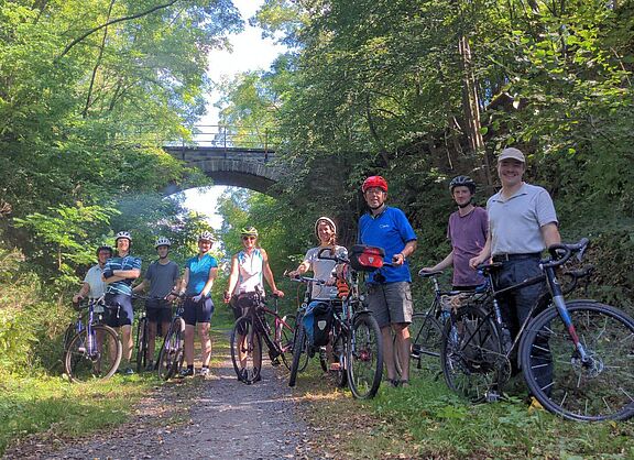Radfahrer auf einem Waldweg vor einer Brücke