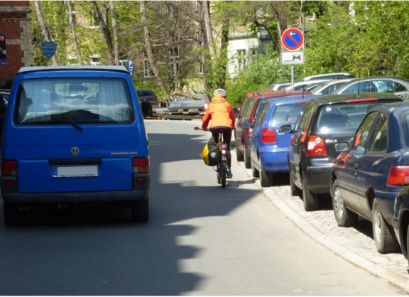 Frau auf Fahrrad wird sehr dicht von einem Auto überholt