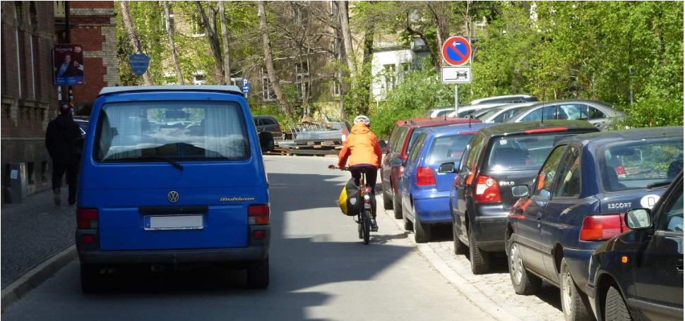 Frau auf Fahrrad wird sehr dicht von einem Auto überholt
