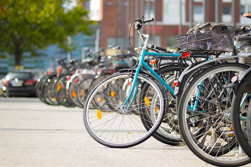 lange Reihe abgestellter Fahrräder verschiedener Farben lange Reihe abgestellter Fahrräder verschiedener Farben