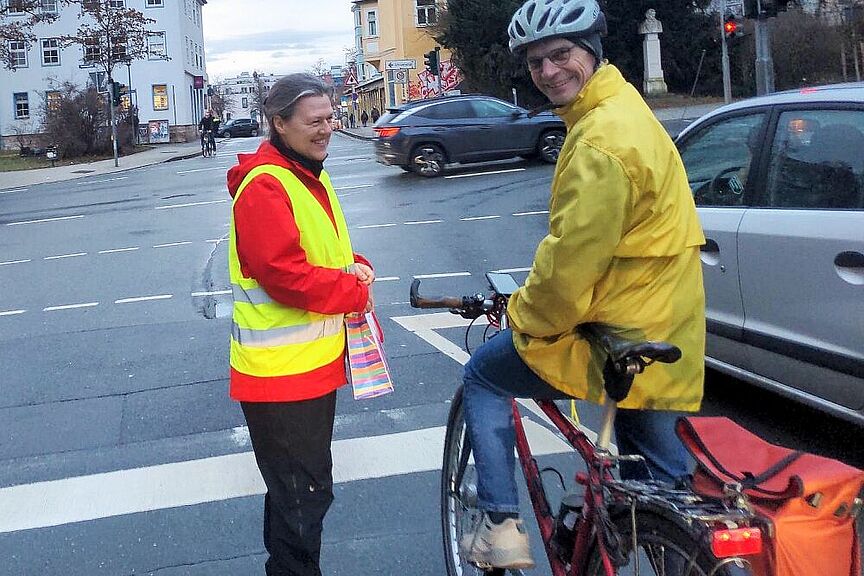 Winter-Bike-To-Work-Day-Aktion Jena 2026 Frau übergibt einem Radfahrer ein Dankeschön