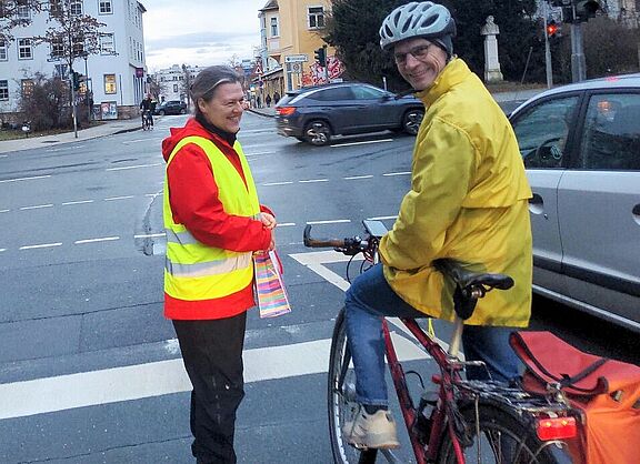 Frau übergibt einem Radfahrer ein Dankeschön