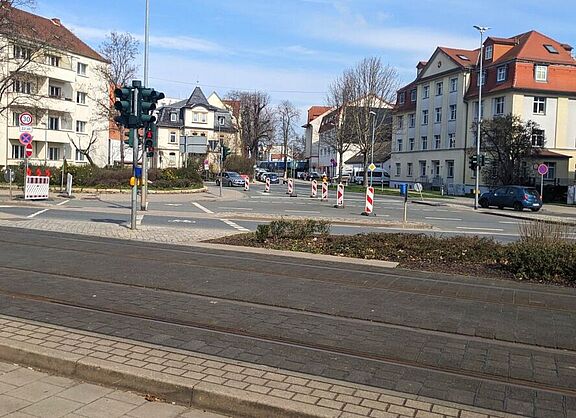 Verkehrskreuzung mit Fußgängerüberweg, Teile der Kreuzung sind mit Barken abgesperrt, im Vordergrund verlaufen Straßenbahnschienen 