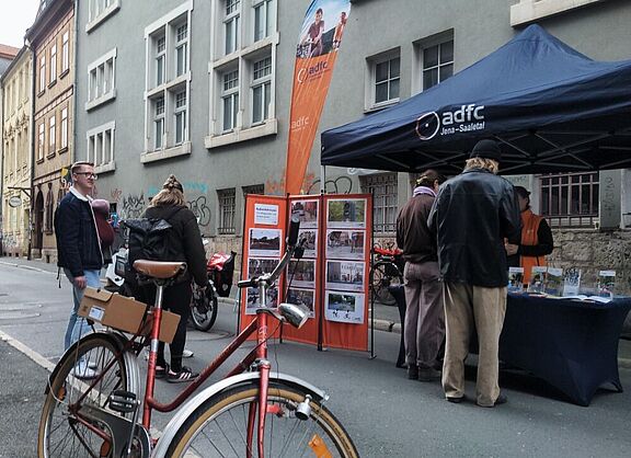 Menschen sprechen an einem Infostand miteinander
