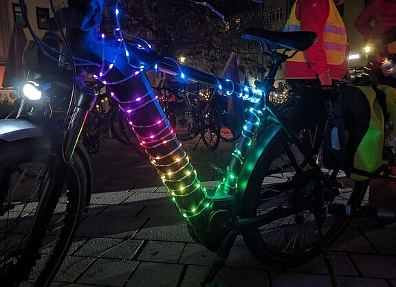 Fahrrad mit Lichterkette in Regenbogenfarben