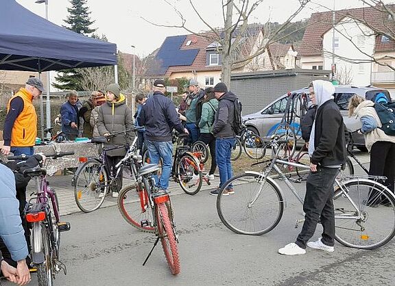 Menschen beugen sich über Fahrräder und diskutieren miteinander