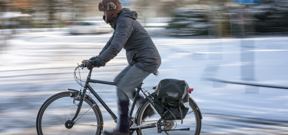 Frau auf Fahrrad vor einer Winterlandschaft. Frau auf Fahrrad vor einer Winterlandschaft.